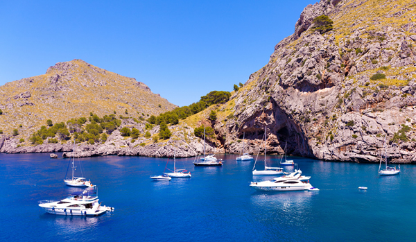 Sailing boats on the rugged coast of Mallorca